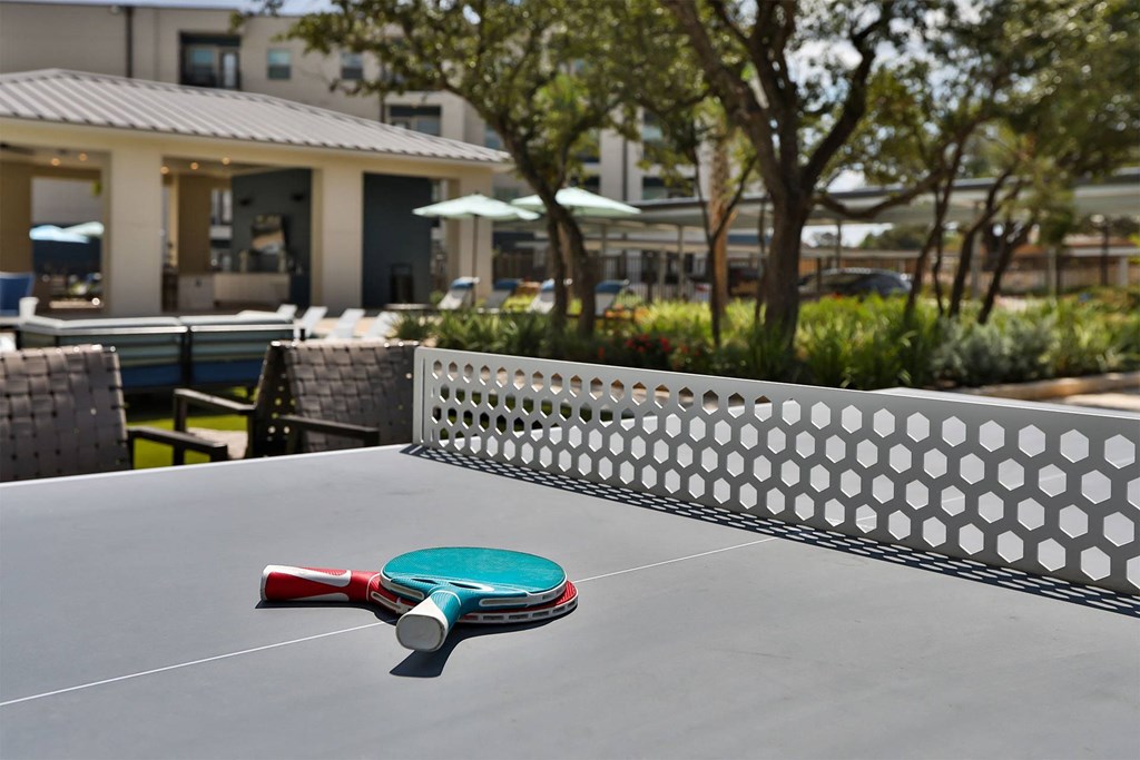 A red and green paddle is on a table tennis table.