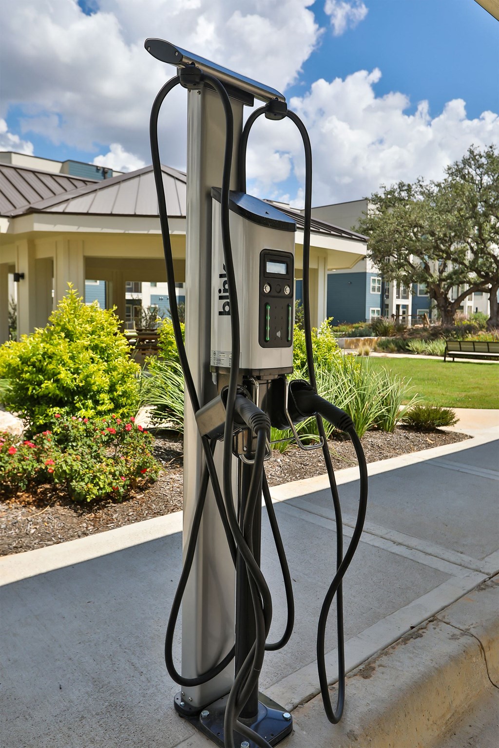 A Bilt car charging station is on the sidewalk.