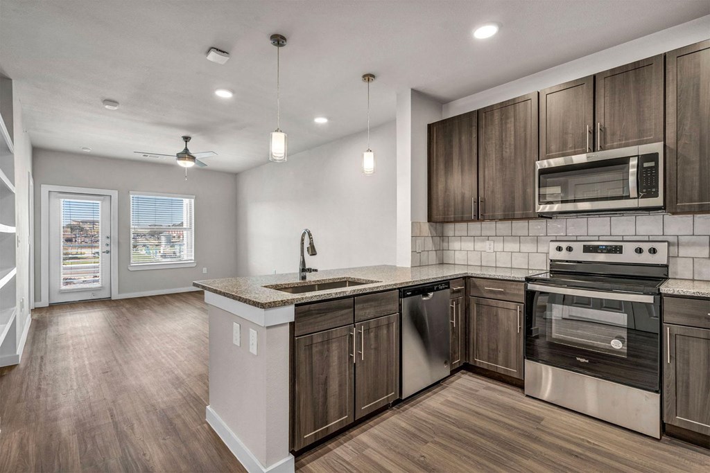 an empty kitchen with wooden cabinets and stainless steel appliances