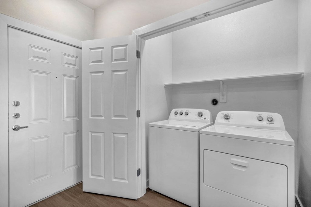 closet with white washer and dryer and white doors