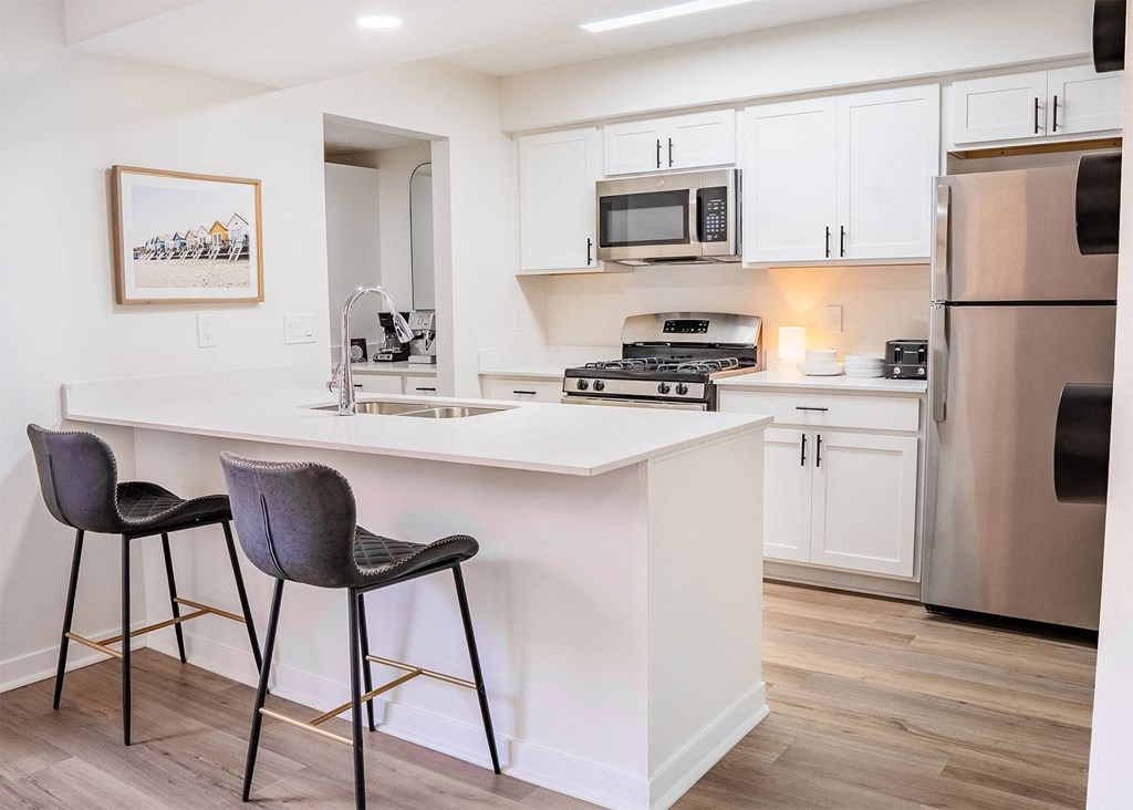 townhome kitchen with stainless steel appliances and peninsula with bar stools
