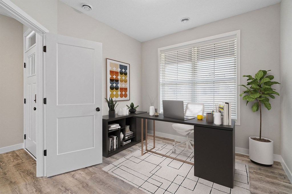 a home office with a desk and a door to a closet