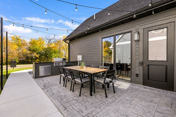 the back patio with a table and chairs and a grill