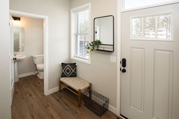 a small bathroom with a toilet and a chair and a mirror