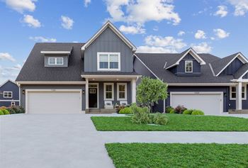 a house with two garage doors and a lawn