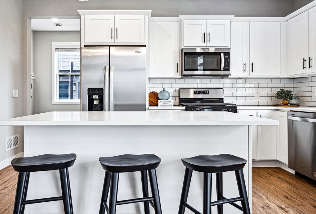 a kitchen with a counter top and three stools