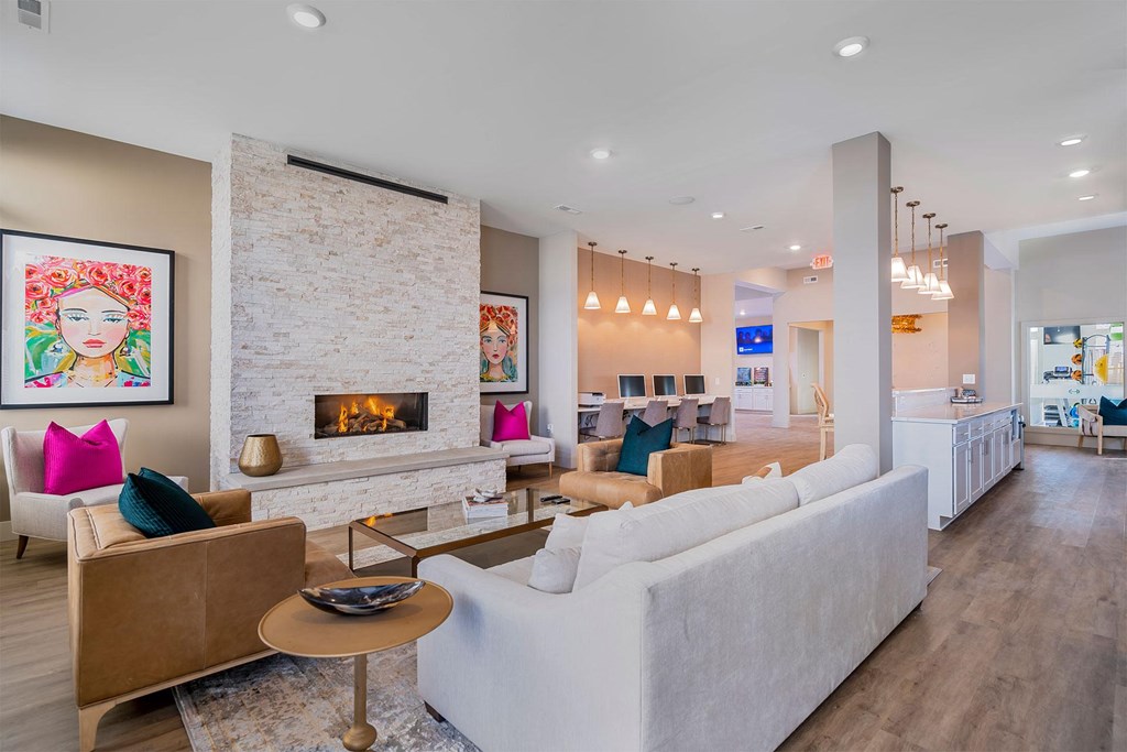 A living room with a fireplace and a painting of a woman's face on the wall.