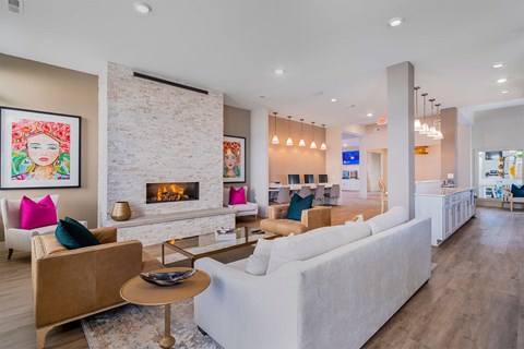 A living room with a fireplace and a painting of a woman's face on the wall.