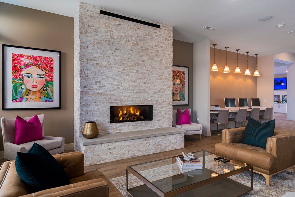 A living room with a fireplace and a painting of a woman.