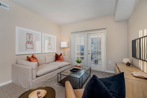 A living room with a grey couch, a coffee table, and a painting on the wall.