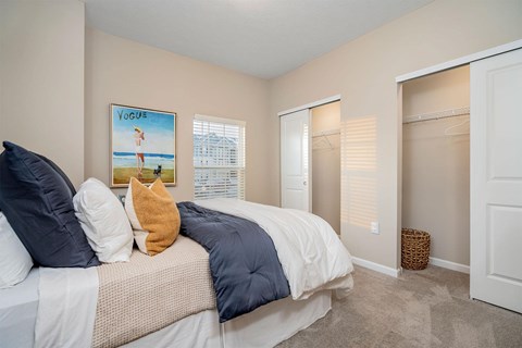 A bedroom with a bed, a poster, and a wicker basket.