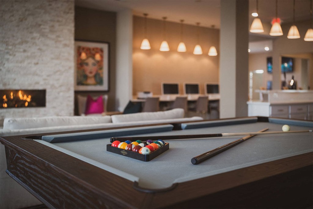A pool table with a set of balls and a cue stick on it.