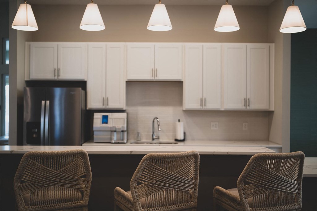 Three chairs are placed in front of a kitchen counter.