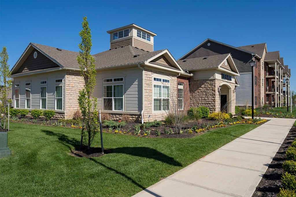 A house with a well-maintained lawn and a clear blue sky.
