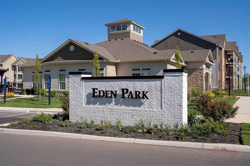 The image shows a sign that says "Eden Park" in front of a building.