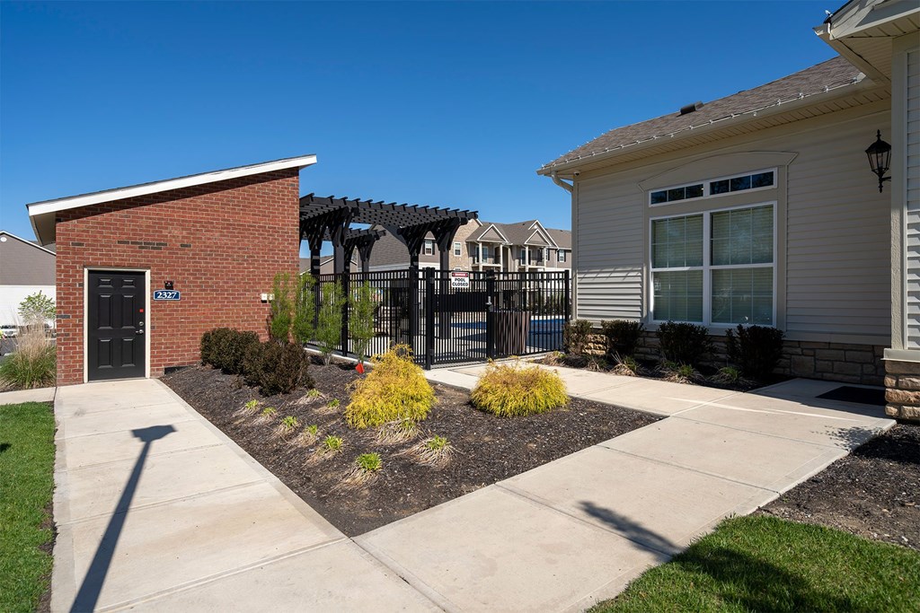 A house with a black door and a brick wall.