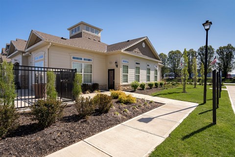 A house with a black fence and a small garden in front.