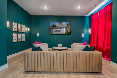 A living room with a brown couch and a red curtain.