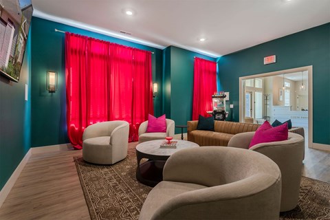 A living room with a red curtain and a brown sofa.