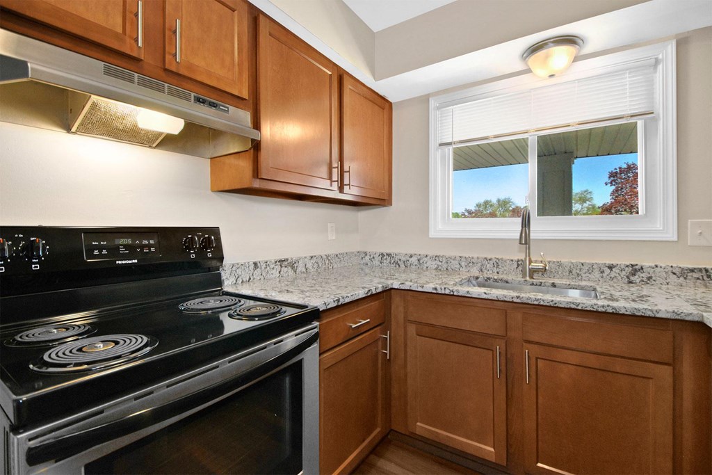 full kitchen with black appliances and granite counter tops and wooden cabinets