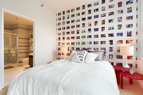 a bedroom with a bed and a wall of photos