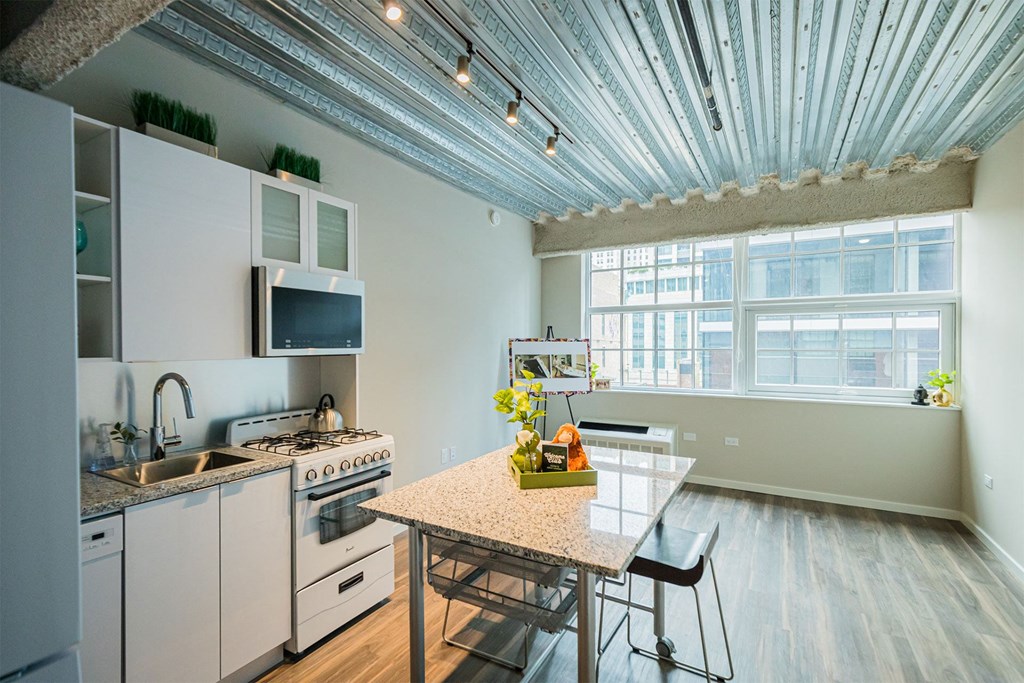 a kitchen with white appliances and a table and a window