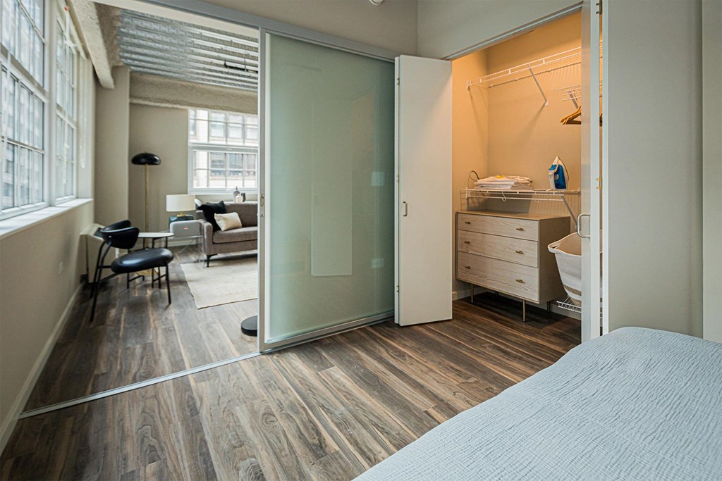 a bedroom with a bed and a bathroom with a sliding glass door