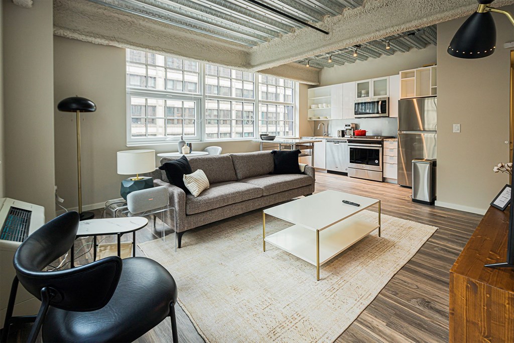 a living room with a couch and a coffee table    and a kitchen