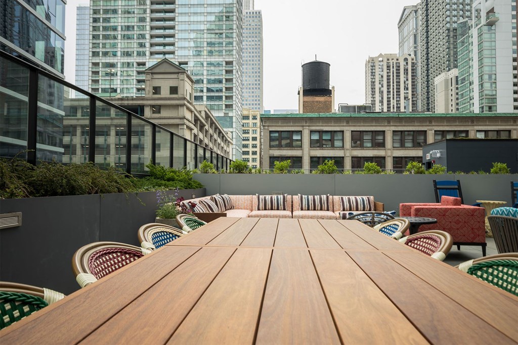 a communal table on a balcony in a city with tall buildings