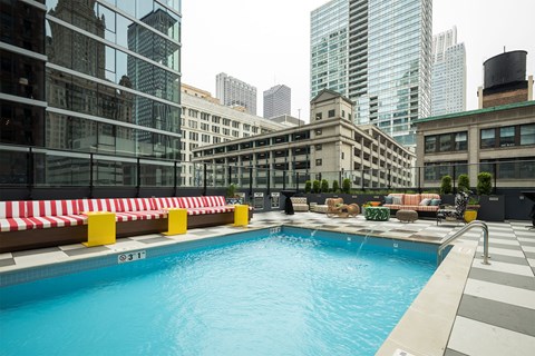 a swimming pool on the rooftop of a building with skyscrapers