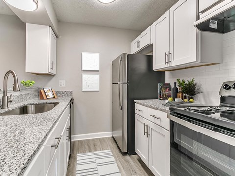 an updated kitchen with granite counter tops and stainless steel appliances