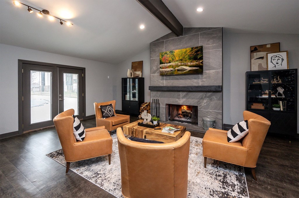 A modern living room with a fireplace and a painting above it.