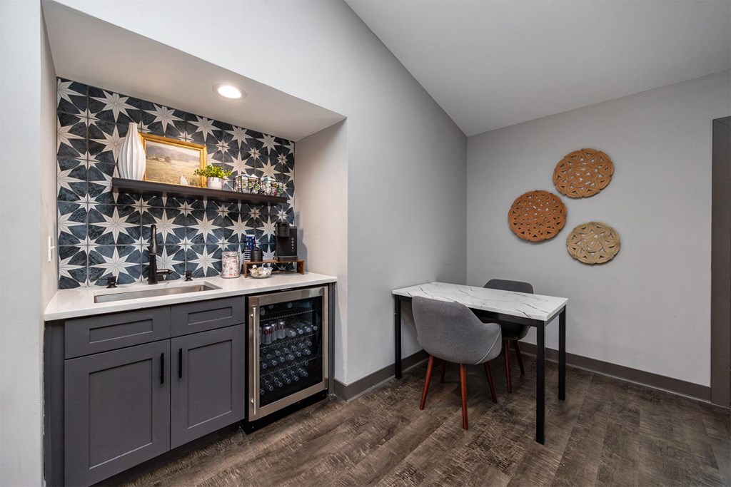 A kitchen with a tile backsplash and a table with chairs.