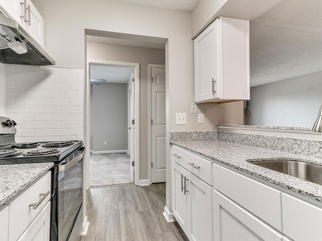 a kitchen with granite counter tops and white cabinets