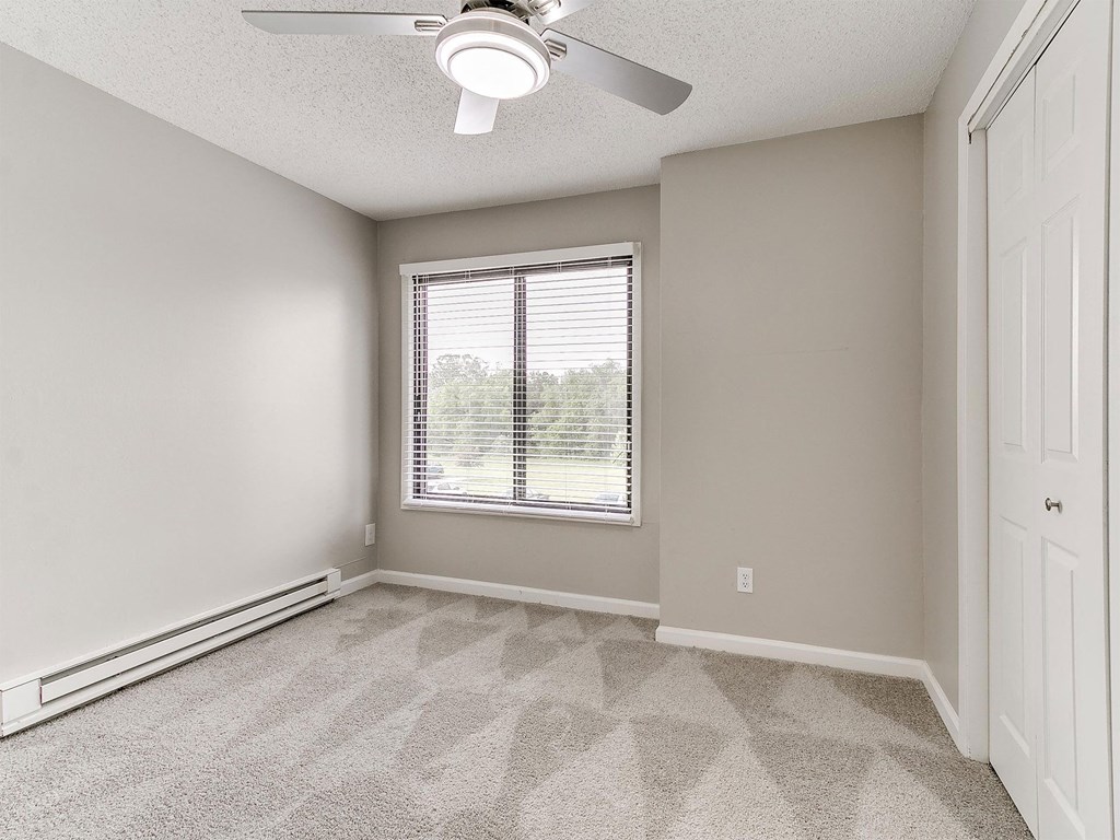 an empty room with white walls and a window
