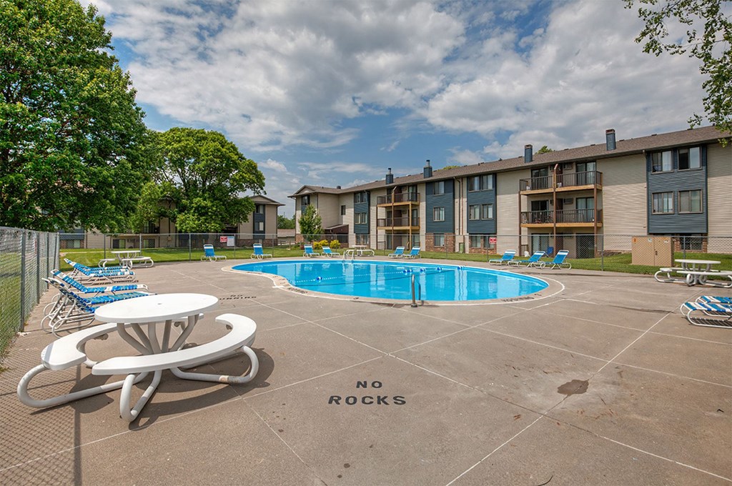 our apartments have a resort style pool with chairs and tables