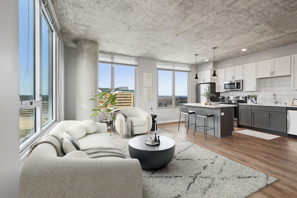 A modern living room with a grey couch and a round table.