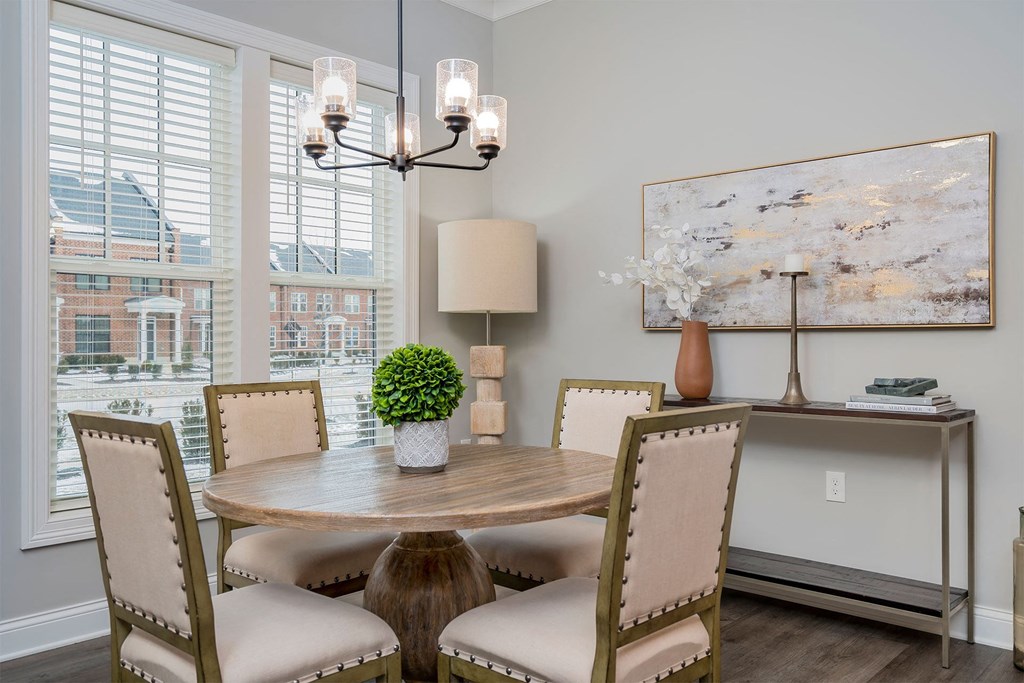 a dining room with a table and chairs and a window