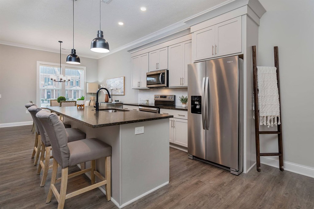 a kitchen with a center island and a stainless steel refrigerator