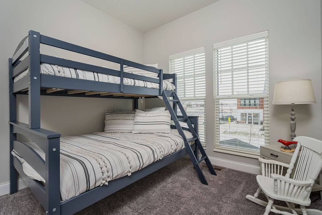 a bedroom with a bunk bed and a window