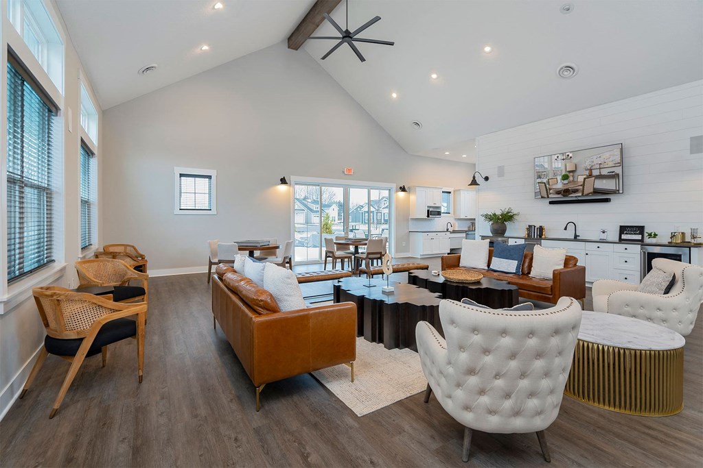 a living room with white walls and furniture and a kitchen