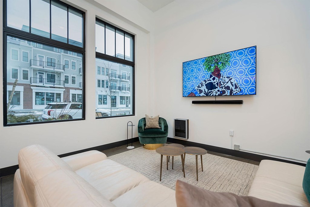 a living room with a couch and a chair and a tv on the wall