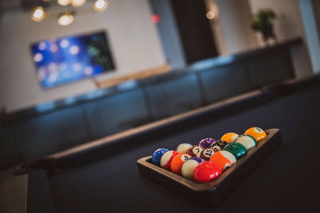 a tray of colorful billiard balls on a table