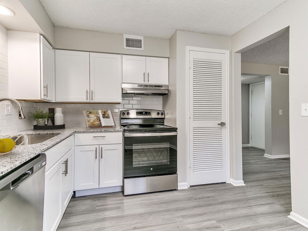 A kitchen with white cabinets and a stainless steel oven.