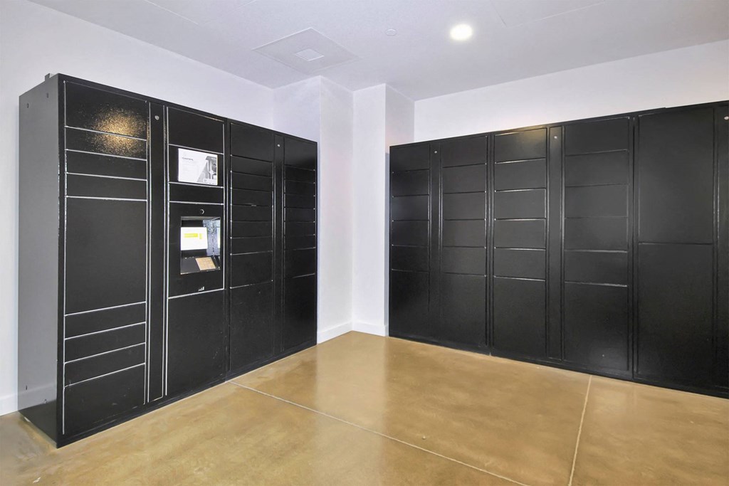 a room with black lockers on the wall and a wooden floor