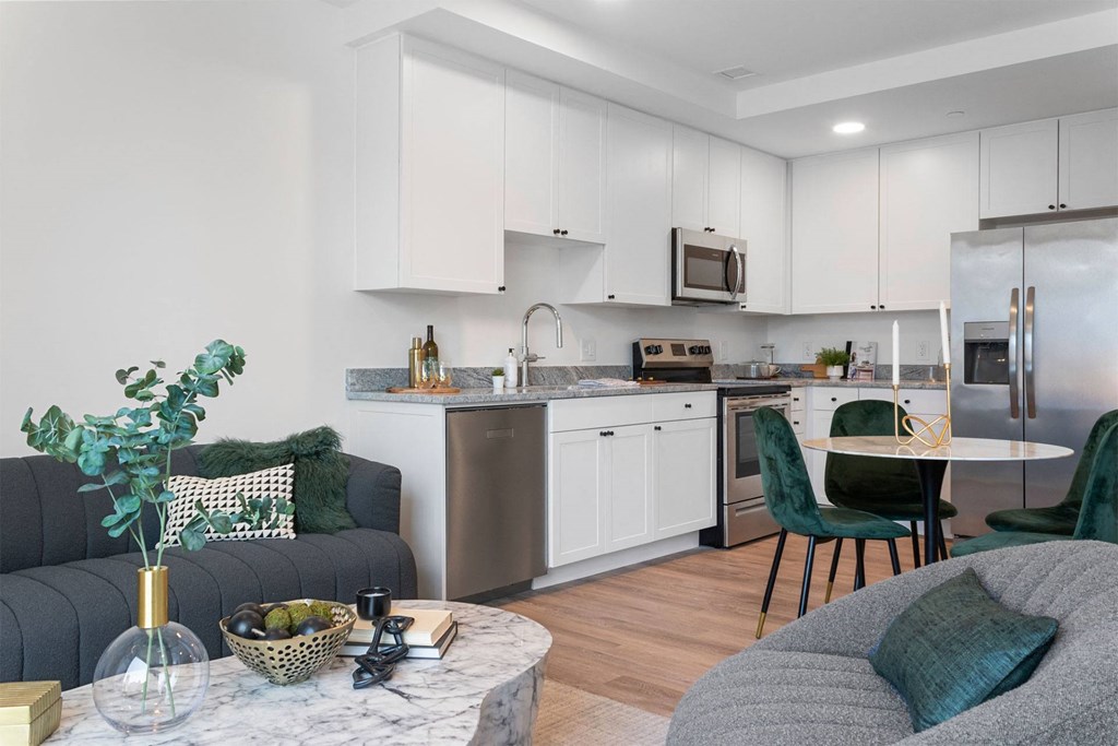 a living room and kitchen with a couch and a table