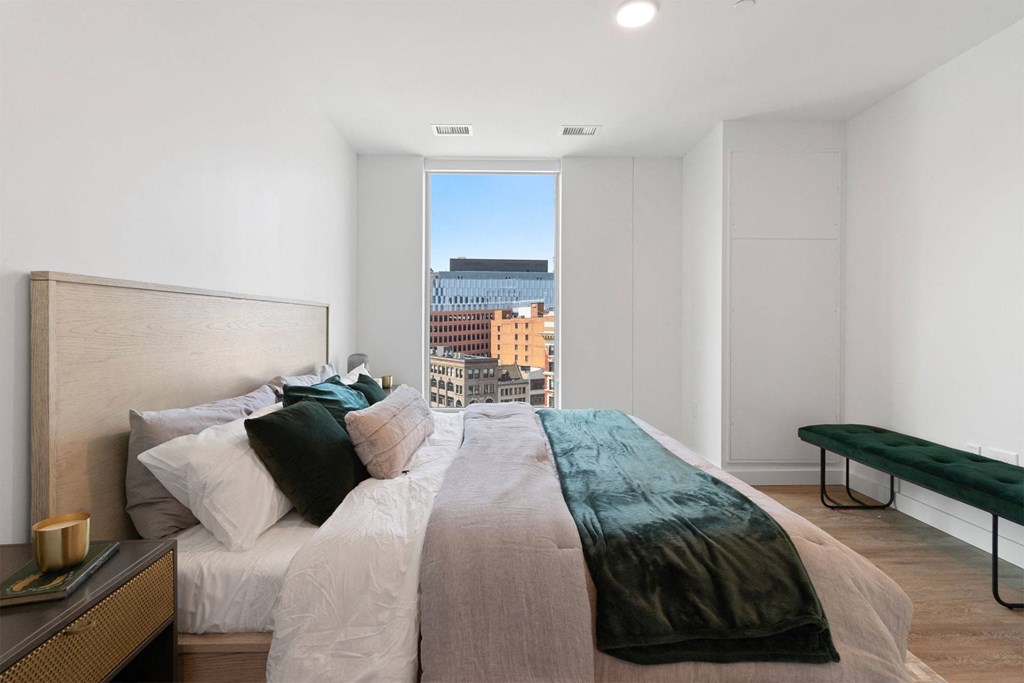 a bedroom with a bed and a large window
