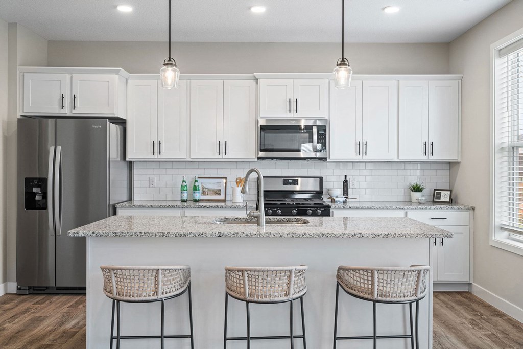 a kitchen with white cabinets and a counter top