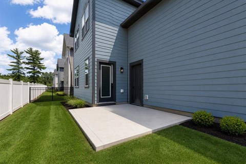 A modern house with a grey exterior and a white fence.