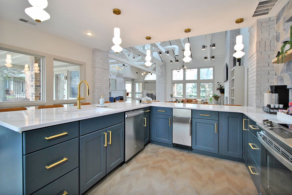 a large kitchen with blue cabinets and white counter tops